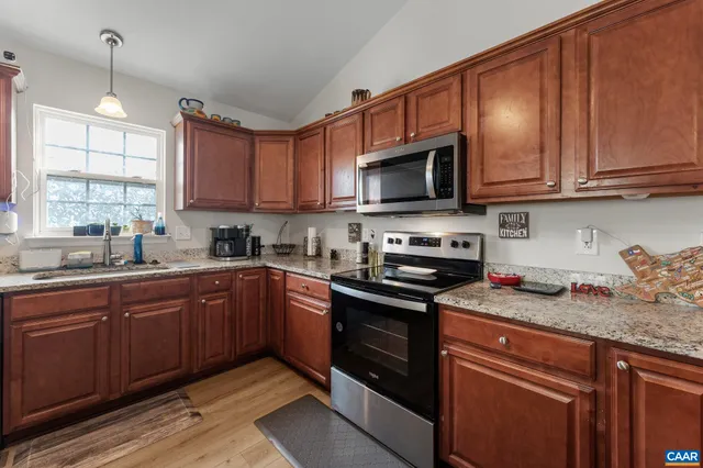 a kitchen with granite countertop wooden cabinets and a sink