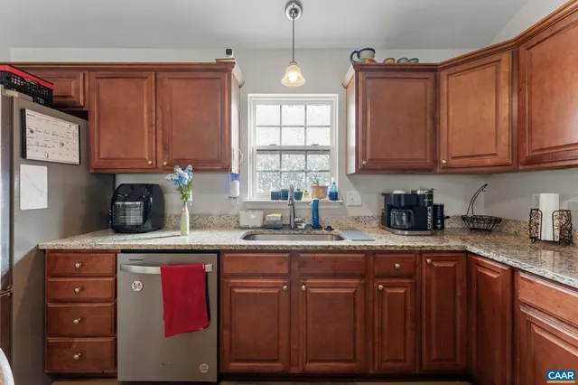 a kitchen with granite countertop a sink cabinets and window
