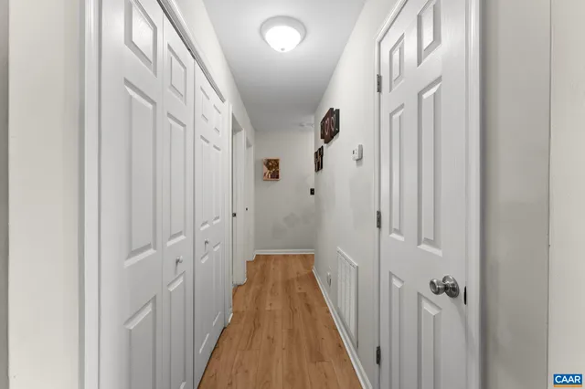a view of a hallway with wooden floor and staircase