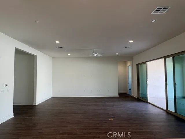 a view of an empty room with wooden floor and closet