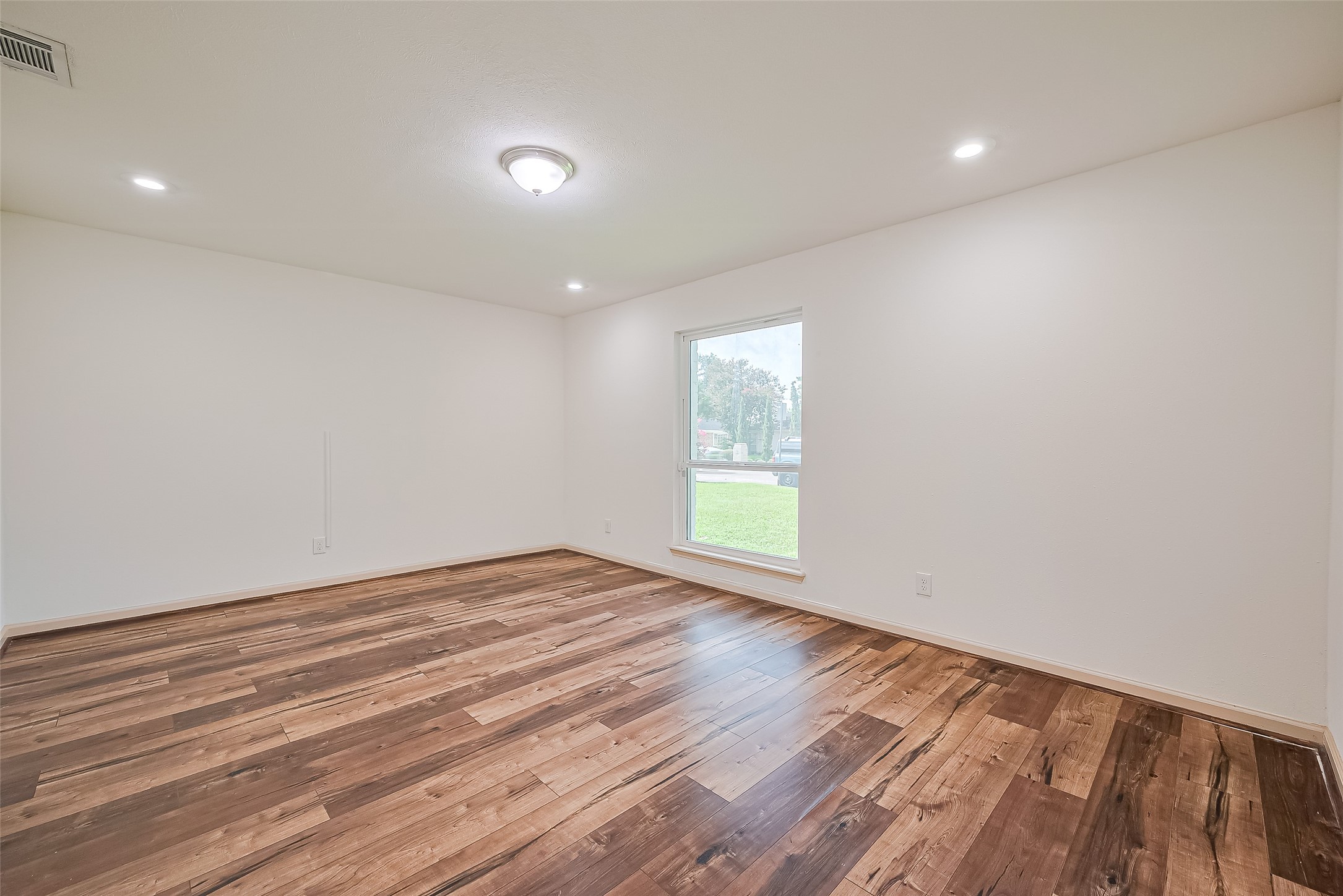 982 West Donovan Street Houston, TX 77091 - Photo 9 of 39 a view of an empty room with wooden floor and a window