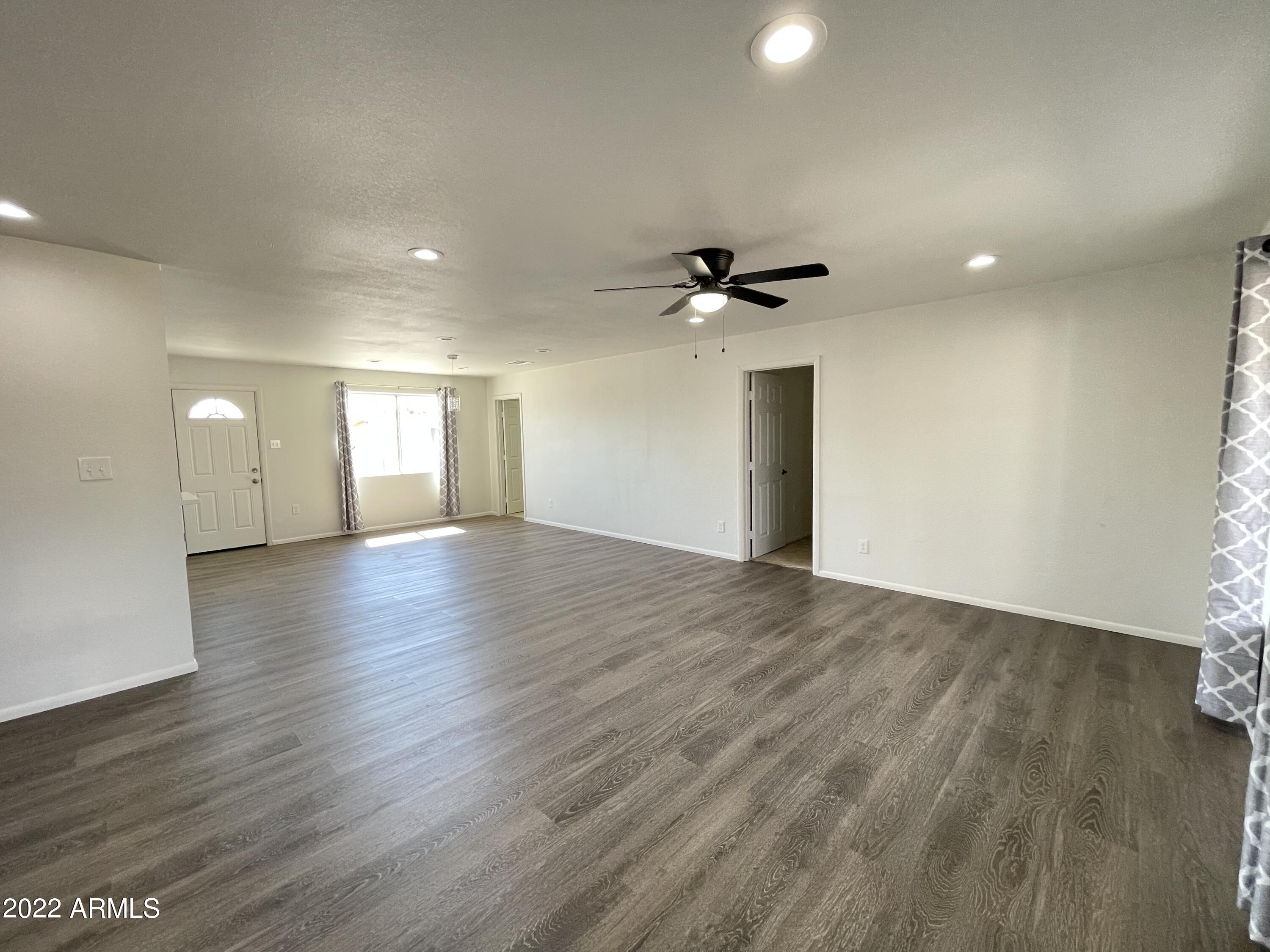 5207 West Osborn Road Phoenix, AZ 85031 - Photo 16 of 35 a view of an empty room with wooden floor and a window