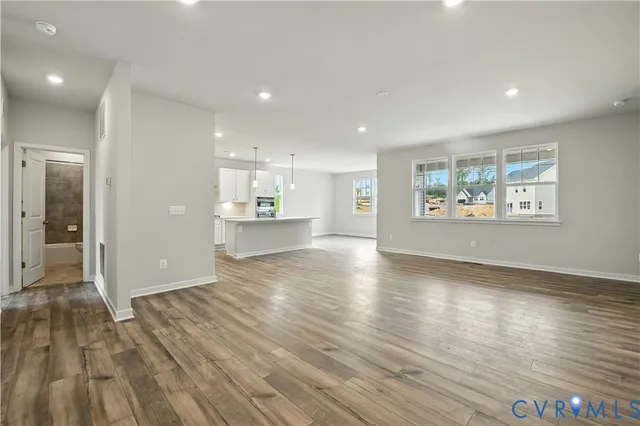 a view of empty room with kitchen and window