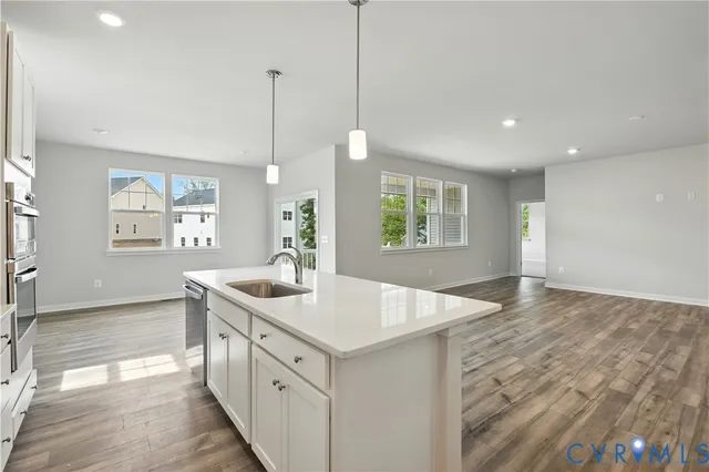 a kitchen with a sink stove and wooden floor