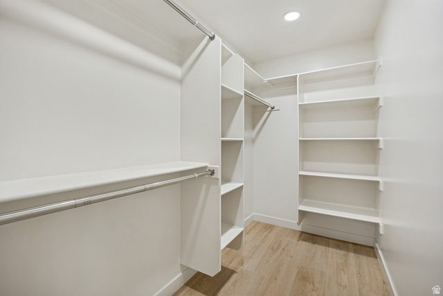 1168 East Center Street Bountiful, UT 84010 - Photo 20 of 38 Walk-in closet featuring light wood-finish flooring, recessed lighting, white built-in shelving, and multiple clothing rods