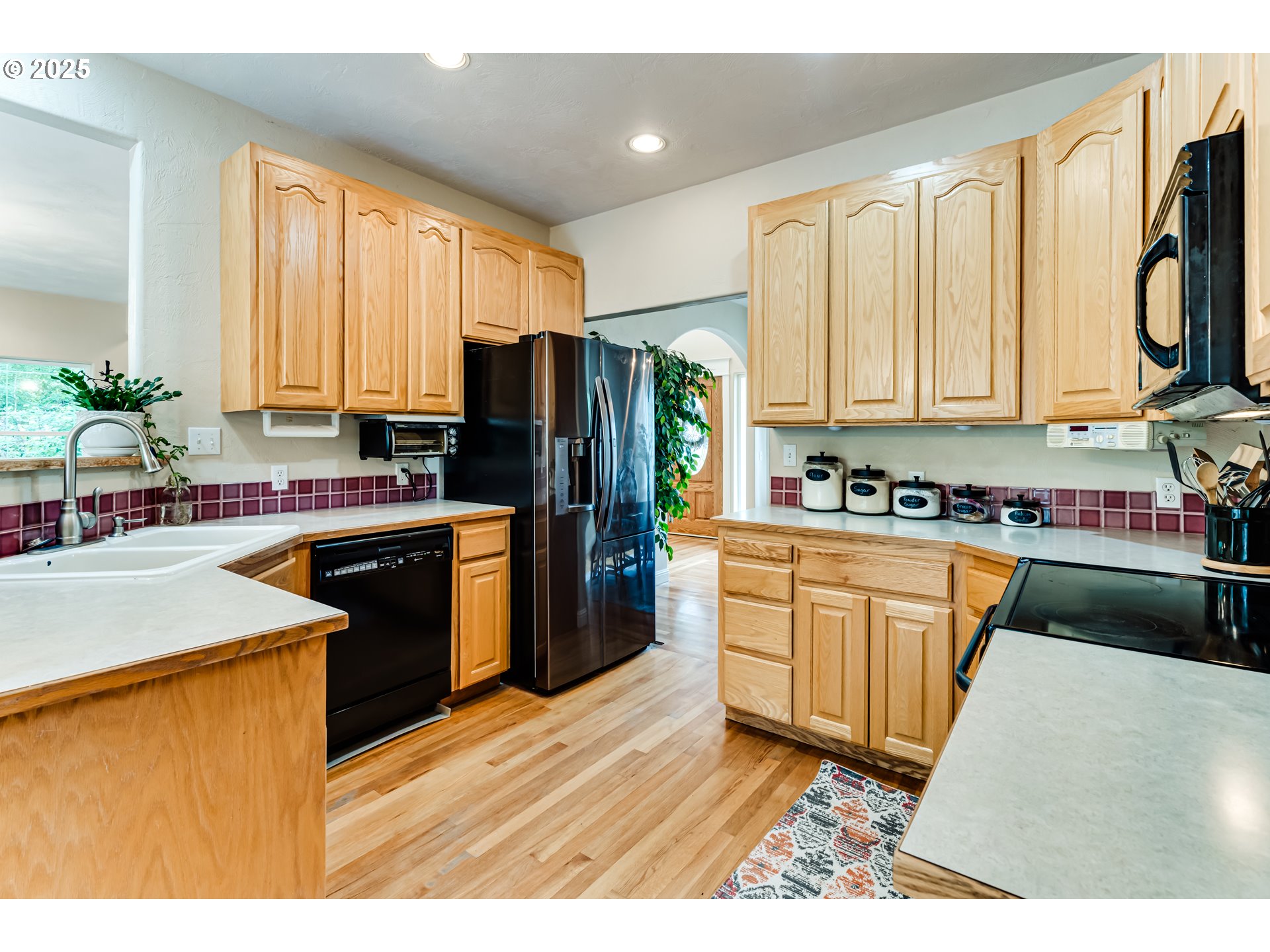 1187 South 69th Street Springfield, OR 97478 - Photo 15 of 42 a kitchen with stainless steel appliances granite countertop a refrigerator a sink dishwasher a stove and white countertops with wooden floor