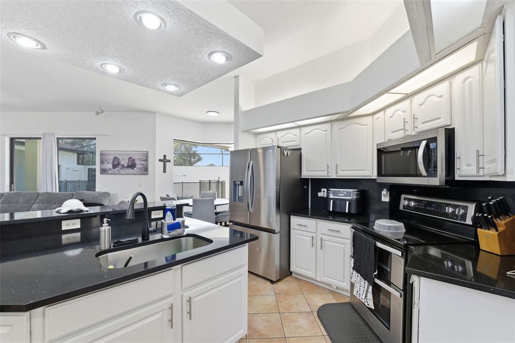 8451 Delta Court Weeki Wachee, FL 34613 - Photo 16 of 64 a kitchen with stainless steel appliances granite countertop a refrigerator a stove and a sink