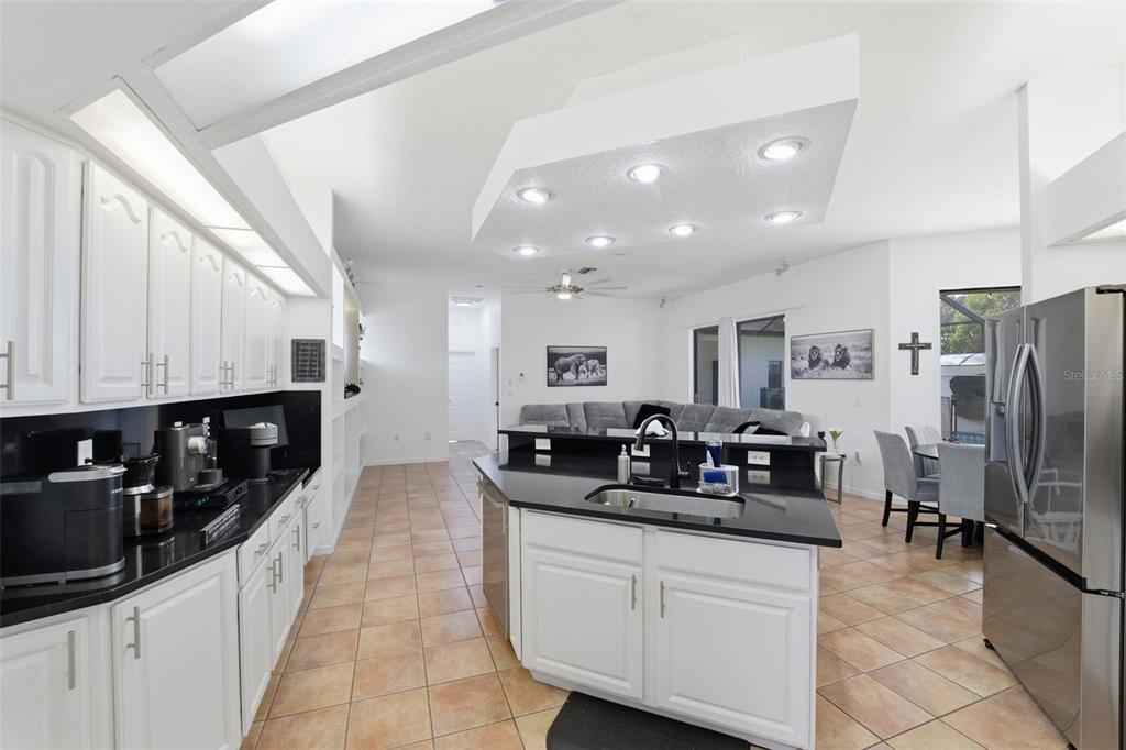 8451 Delta Court Weeki Wachee, FL 34613 - Photo 17 of 64 a kitchen with stainless steel appliances a sink a stove a refrigerator cabinets and a dining table