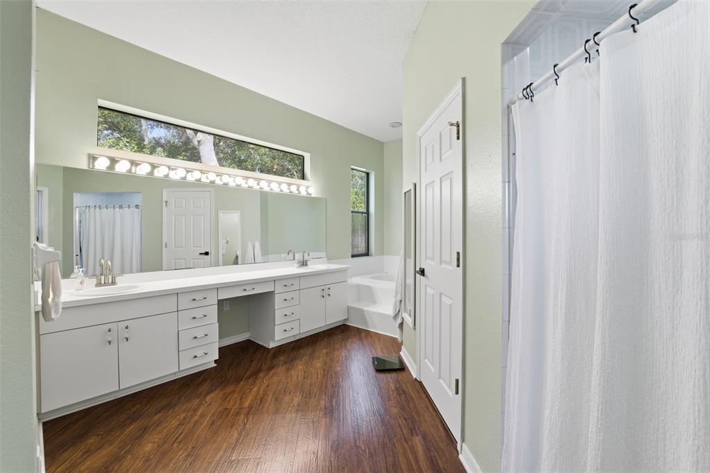 8451 Delta Court Weeki Wachee, FL 34613 - Photo 33 of 64 a bathroom with a double vanity sink a large mirror and a bathtub