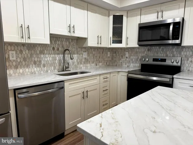 a view of a hallway with wooden floor and cabinet