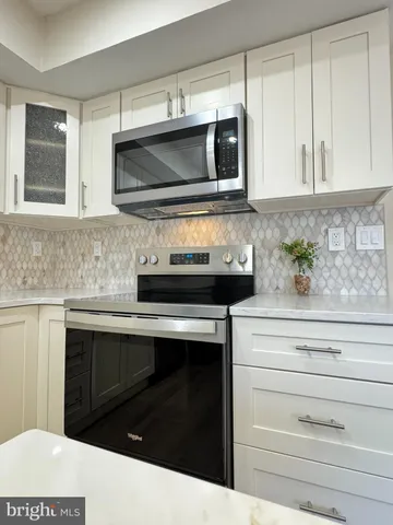 a kitchen with stainless steel appliances white cabinets and a sink
