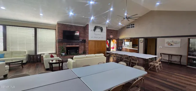 a living room with furniture kitchen view and a large window