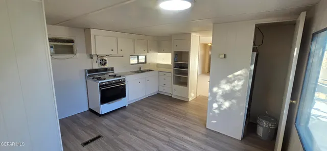 a kitchen with cabinets and wooden floor