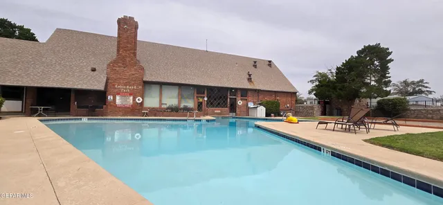 a view of a swimming pool with outdoor seating and a potted plants