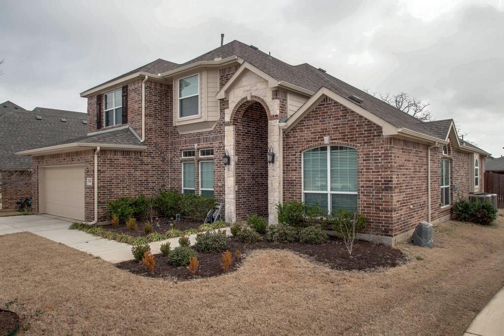 4117 Autumn Path Road Denton, TX 76208 - Photo 2 of 4 Two-story brick and stone facade residence featuring an arched entryway, bay windows, and a two-car garage