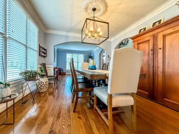 a dining room with furniture a chandelier and wooden floor