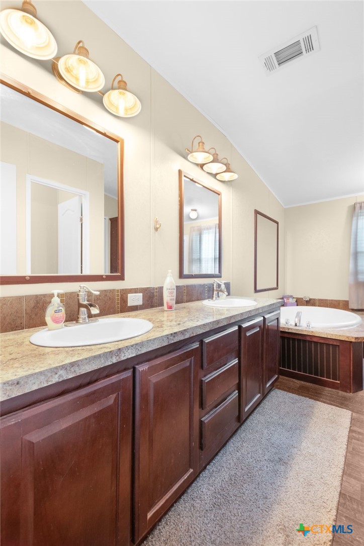 411 Private Road 3447 Kempner, TX 76539 - Photo 5 of 33 a spacious bathroom with a granite countertop double vanity sink and a mirror