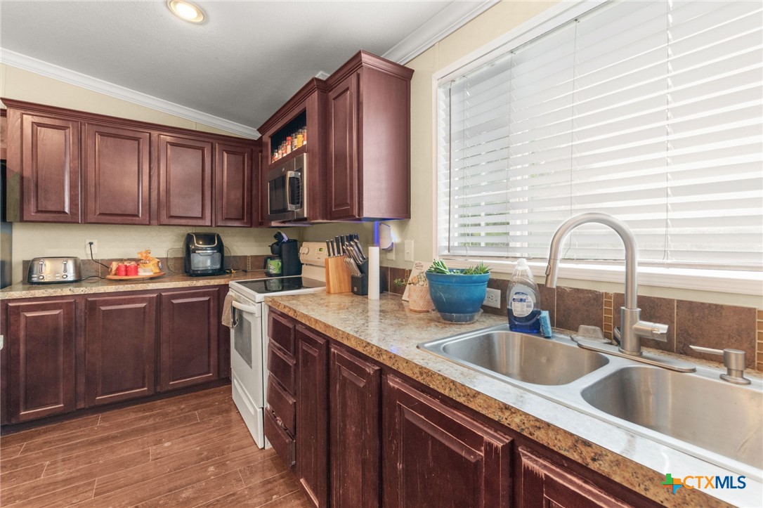 411 Private Road 3447 Kempner, TX 76539 - Photo 8 of 33 a kitchen with granite countertop a sink stove and cabinets