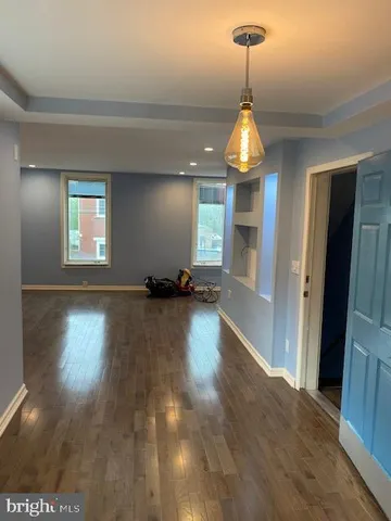 a view of a room with wooden floor chandelier and windows