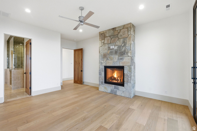 2155 East Wrangler Road Kamas, UT 84036 - Photo 45 of 62 Unfurnished living room with light wood-style flooring, a stone fireplace, and a ceiling fan