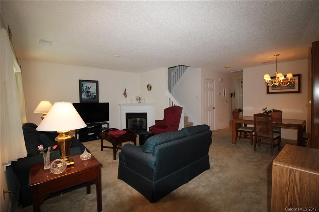 8272 Rudolph Road, Unit 8272 Charlotte, NC 28216 - Photo 2 of 17 a living room with furniture a lamp and a fireplace