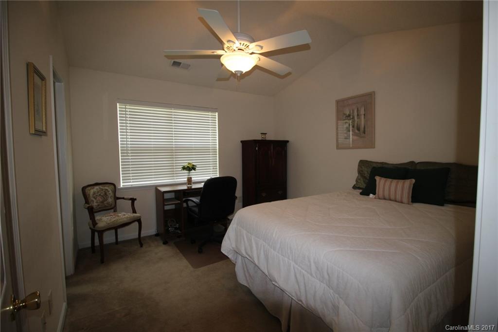 8272 Rudolph Road, Unit 8272 Charlotte, NC 28216 - Photo 13 of 17 a bed room with a bed and a chandelier