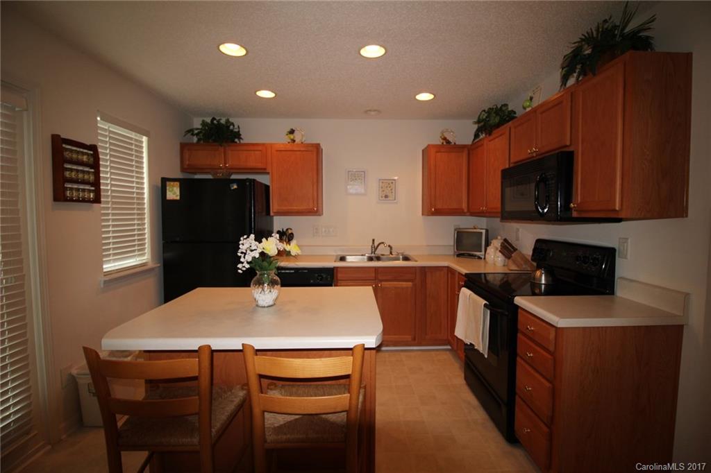 8272 Rudolph Road, Unit 8272 Charlotte, NC 28216 - Photo 7 of 17 a kitchen with a table chairs refrigerator and microwave