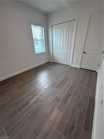 an empty room with wooden floor and window