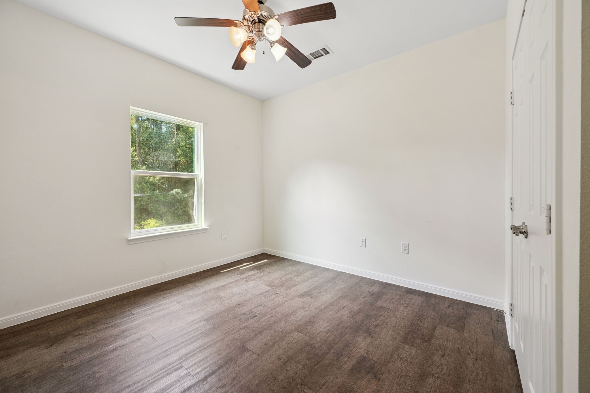325 Cemetery Road Coldspring, TX 77331 - Photo 19 of 31 an empty room with a window and a fan