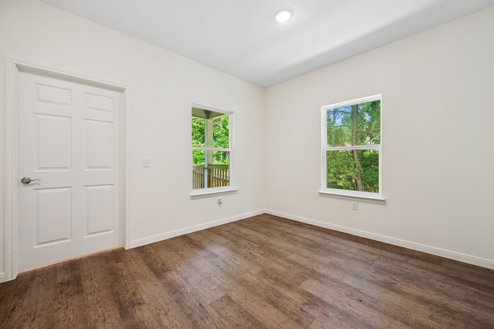 325 Cemetery Road Coldspring, TX 77331 - Photo 22 of 31 an empty room with wooden floor and windows