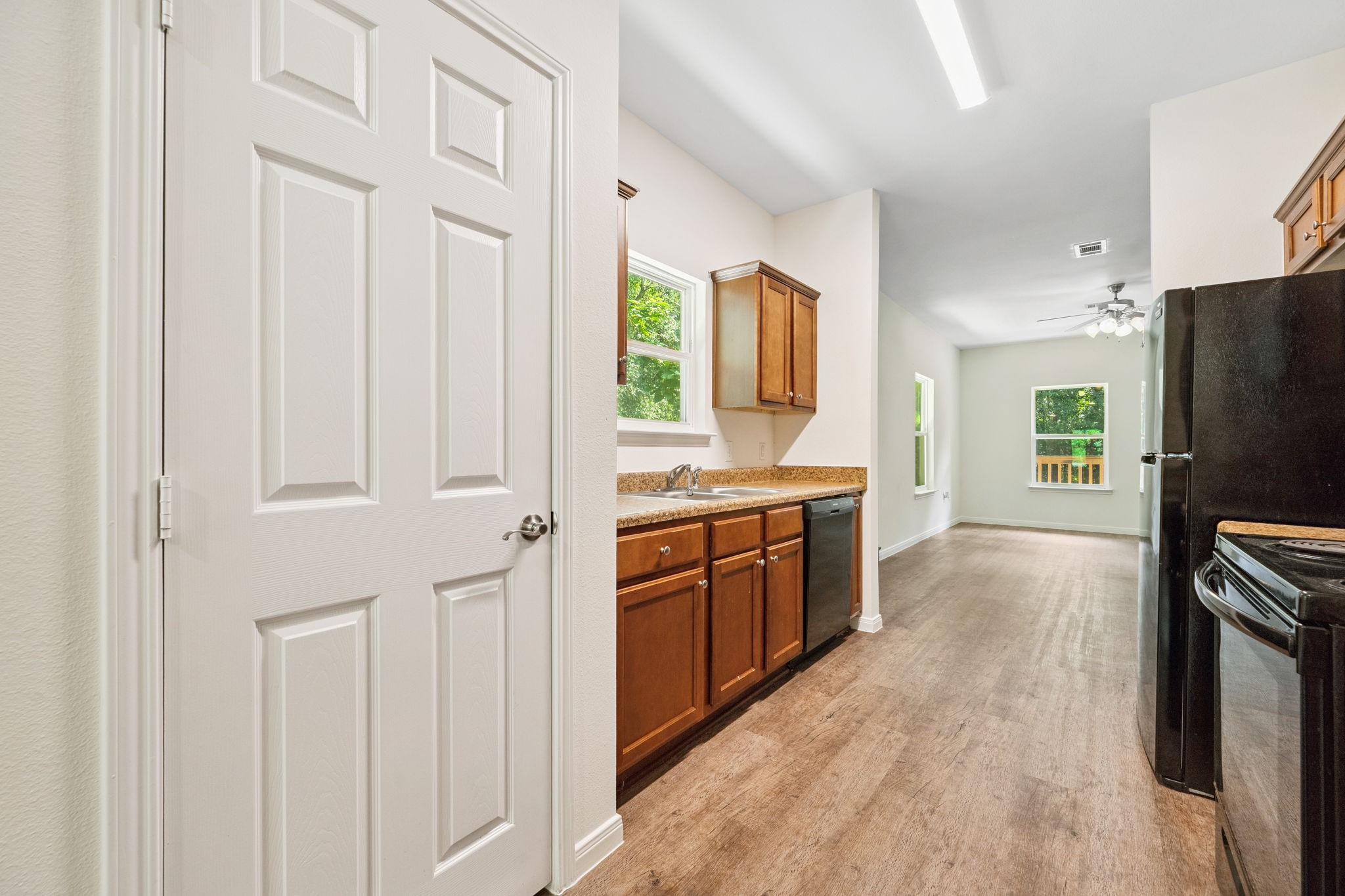 325 Cemetery Road Coldspring, TX 77331 - Photo 8 of 31 a large kitchen with kitchen island granite countertop a refrigerator oven a sink dishwasher and white cabinets with wooden floor