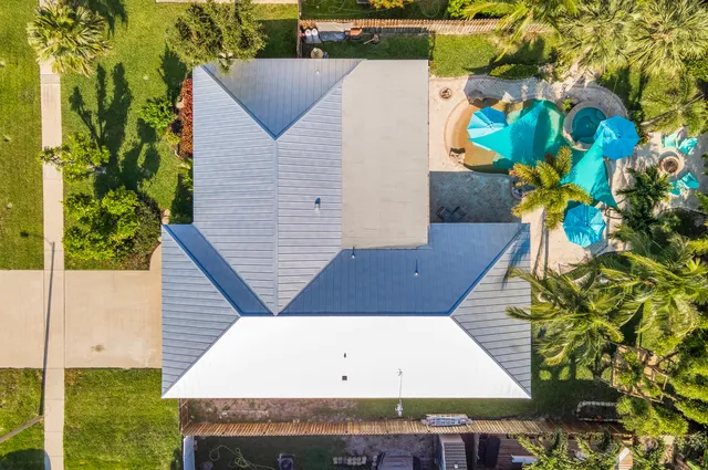 a view of a house with a yard and potted plants