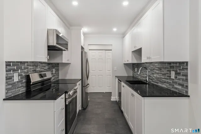 a kitchen with a sink stove top oven and cabinets