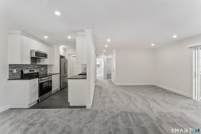 a kitchen with a refrigerator and a stove top oven