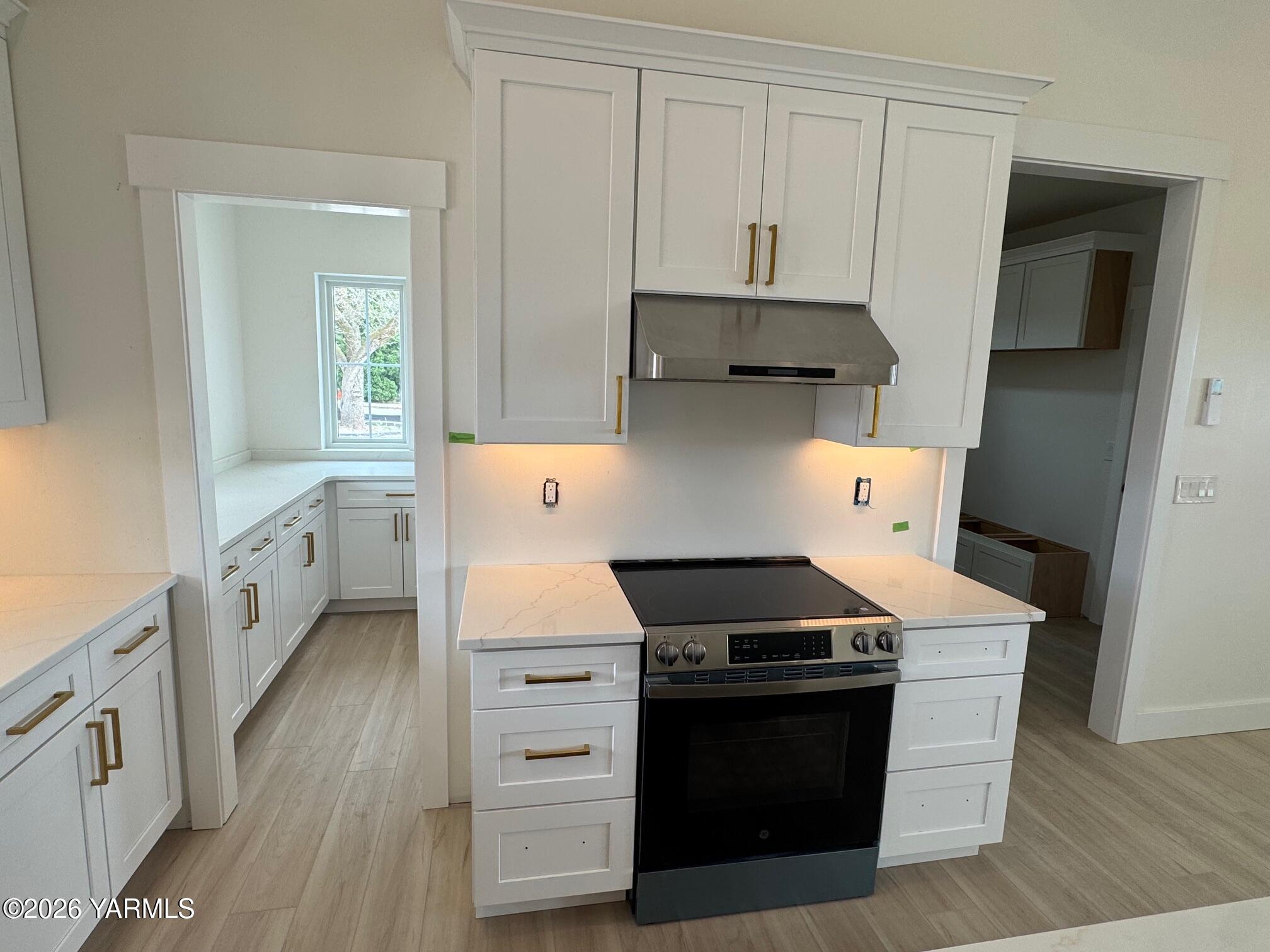 304 6th Street Zillah, WA 98953 - Photo 7 of 29 a kitchen with stainless steel appliances white cabinets and wooden floor