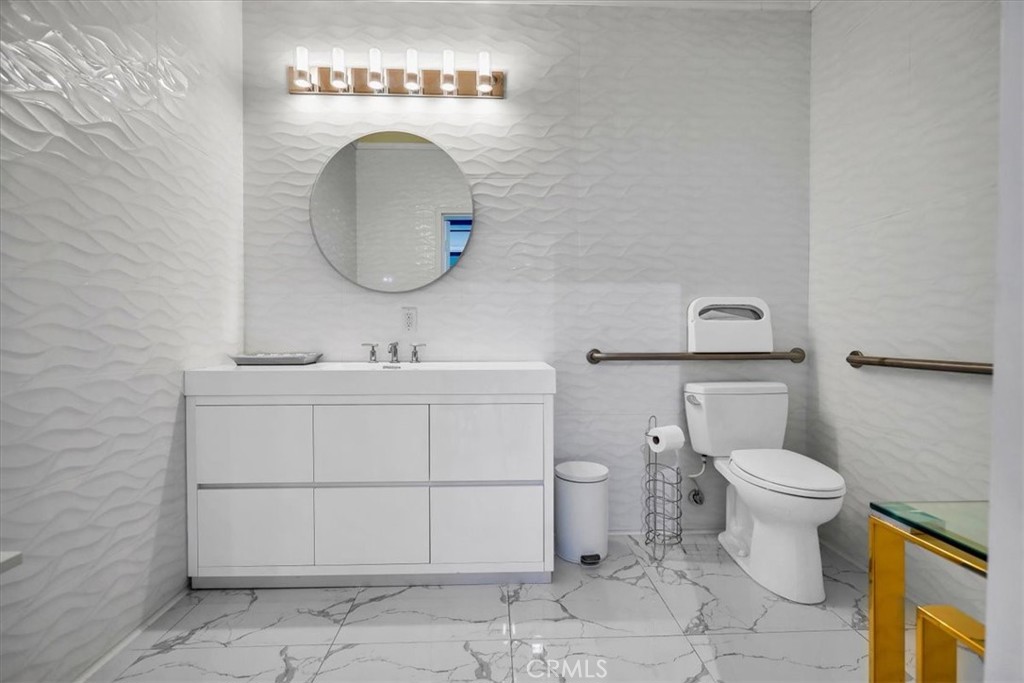 300 East 4th Street, Unit 103 Long Beach, CA 90802 - Photo 22 of 75 a bathroom with a toilet sink and mirror