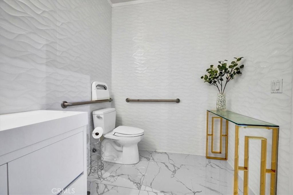 300 East 4th Street, Unit 103 Long Beach, CA 90802 - Photo 23 of 75 a bathroom with a toilet a sink and mirror