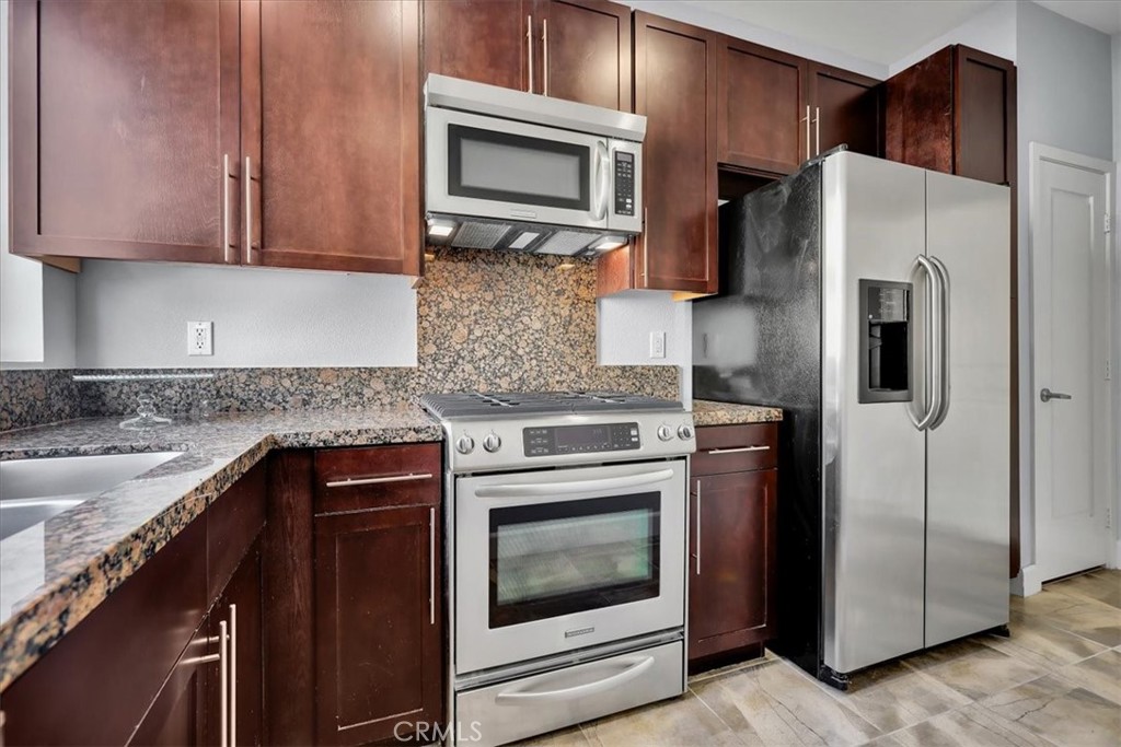 300 East 4th Street, Unit 103 Long Beach, CA 90802 - Photo 40 of 75 a kitchen with stainless steel appliances granite countertop a refrigerator stove and sink