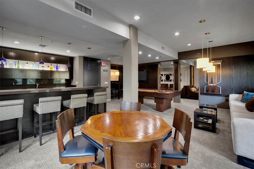 300 East 4th Street, Unit 103 Long Beach, CA 90802 - Photo 55 of 75 a kitchen with stainless steel appliances kitchen island granite countertop a sink a stove a dining table and chairs