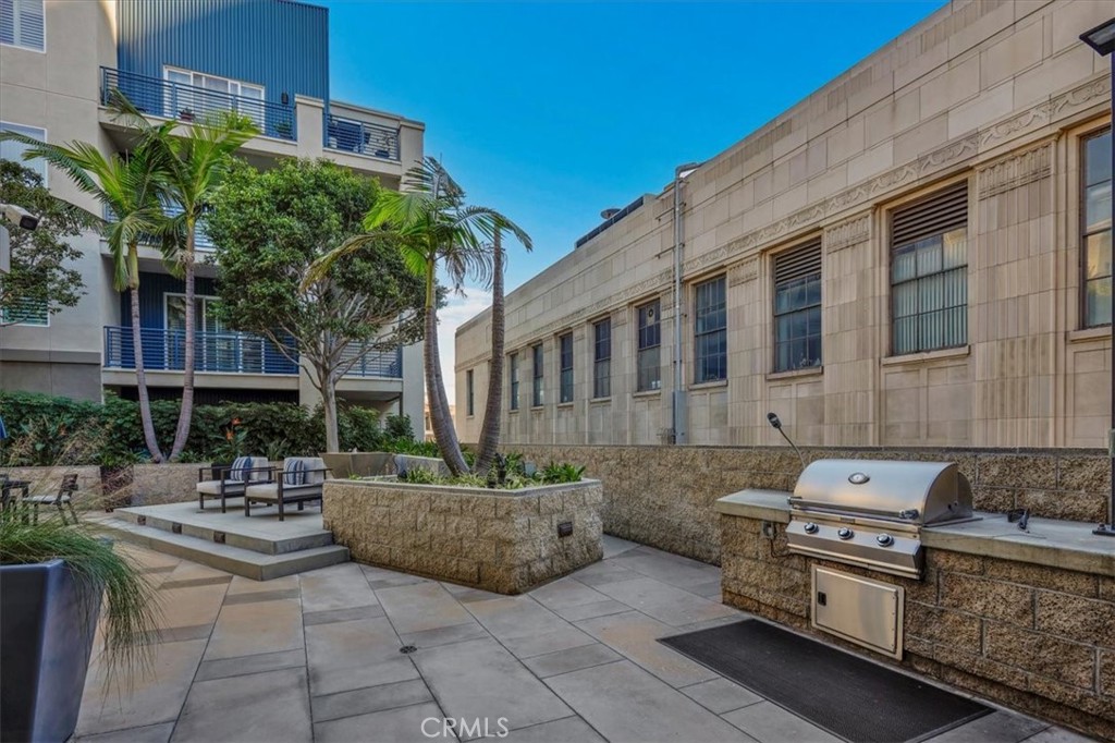 300 East 4th Street, Unit 103 Long Beach, CA 90802 - Photo 63 of 75 a view of a patio with table and chairs potted plants and a large tree