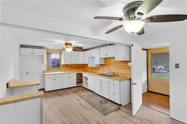 a large kitchen with a wooden floor and cabinets