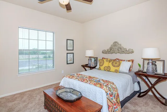 a bedroom with a bed and a dresser next to a window