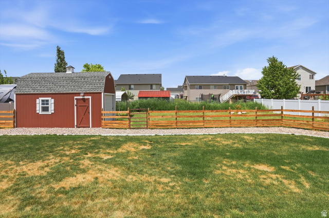 3636 West 910 South Syracuse, UT 84075 - Photo 69 of 70 Expansive backyard featuring a red barn-style shed with white trim, a gabled roof, and a cupola