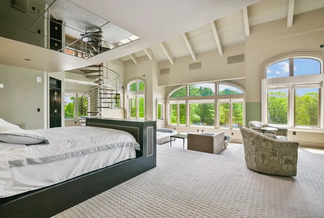 a bedroom with a large bed and windows