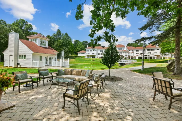 a view of a house with a yard table and chairs