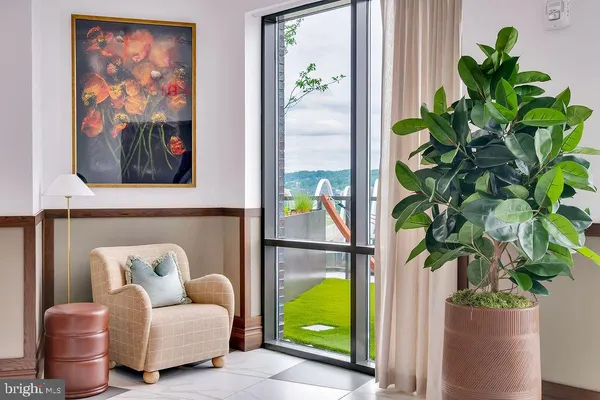a living room with stainless steel appliances granite countertop furniture and a large window