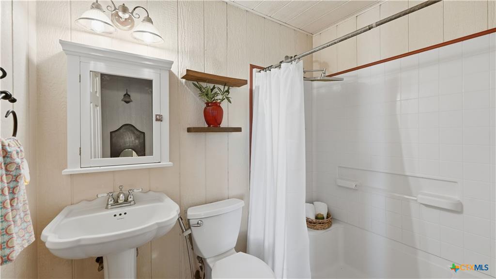 127 Offer Llano, TX 78643 - Photo 22 of 40 Pedestal sink with chrome faucet, complemented by a medicine cabinet with integrated lighting