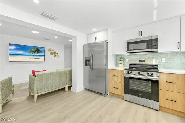 a kitchen with stainless steel appliances granite countertop a refrigerator and a stove top oven