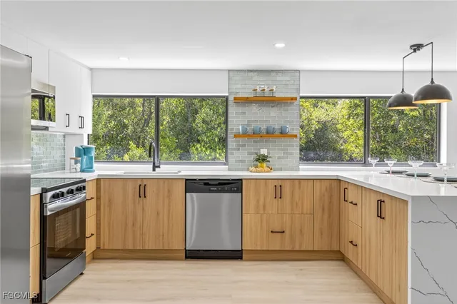 a kitchen with stainless steel appliances a stove sink and cabinets