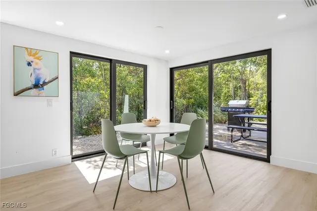 a dining room with furniture large windows and wooden floor
